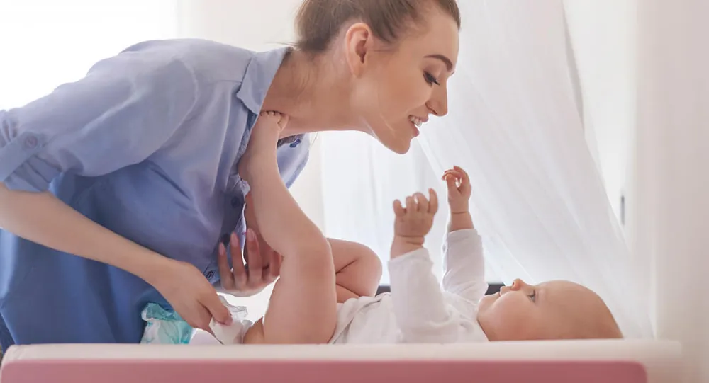 Parent changing a baby’s nappy on a changing mat