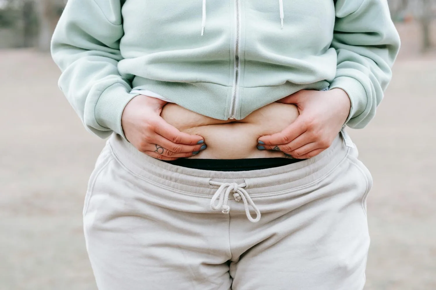 Person holding excess weight around the waistline